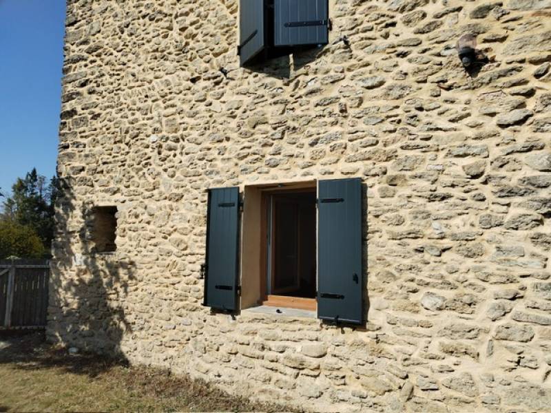 Volets aluminium gris anthracite posés sur une façade en pierre à Entrechaux